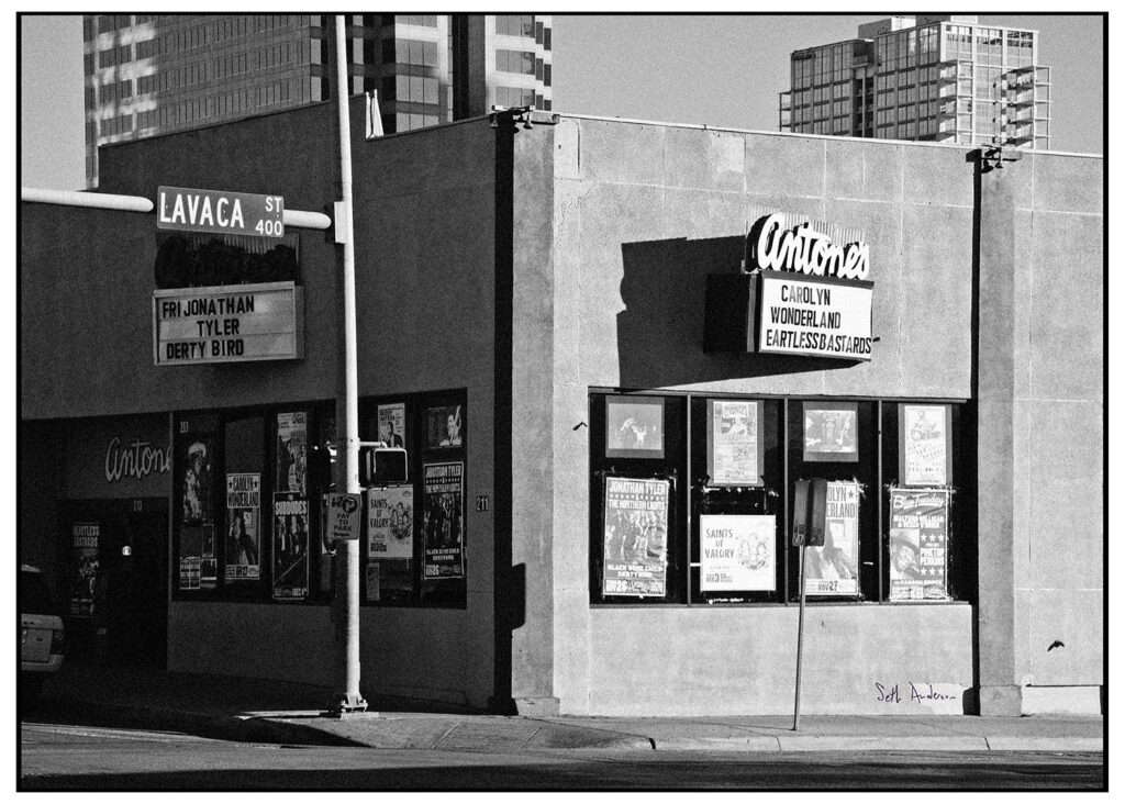 Black-and-white photo of Antone's former nightclub on Lavaca Street with its marquee and posters