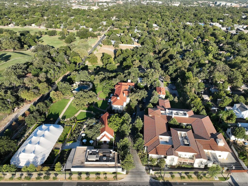 Aerial view of the Commodore Perry Estate in central Austin, with its red-tiled mansion, pool and gardens among dense trees