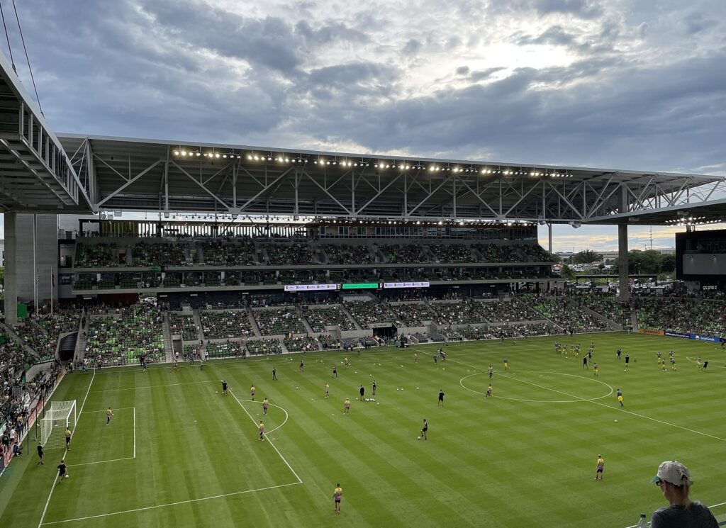 Austin FC playing in front of a packed crowd at Q2 Stadium, the first stop in any Austin sports guide, under an evening sky