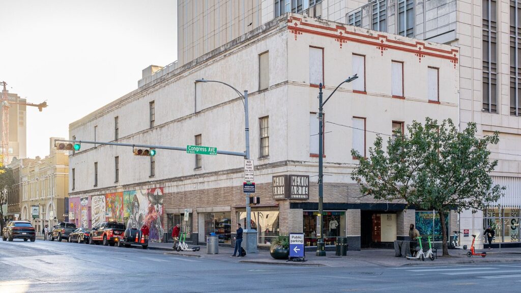 The Mexic-Arte Museum's cream-colored corner building on Congress Avenue in downtown Austin, with colorful murals at street level
