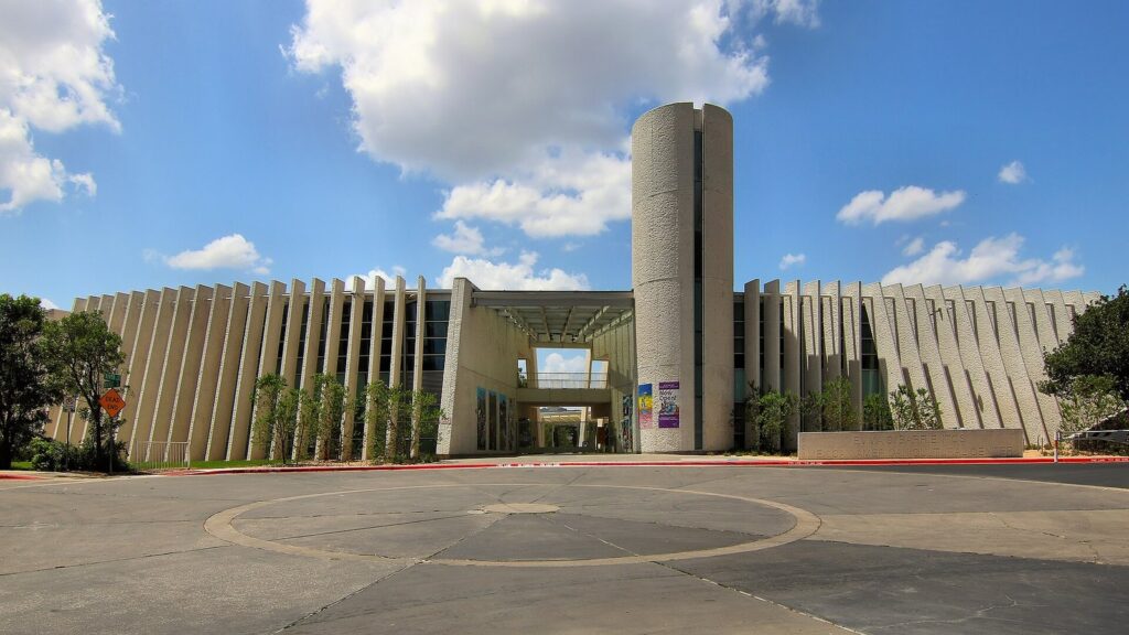 The Emma S. Barrientos Mexican American Cultural Center, a cornerstone of Austin museums and culture, with white vertical fins, a cylindrical tower and a broad plaza