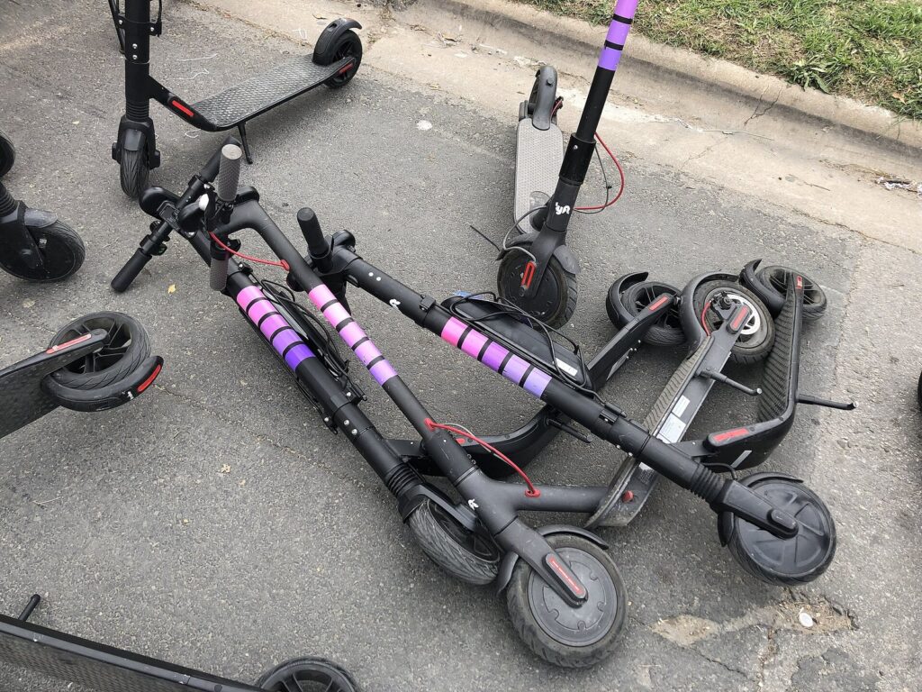 A tangle of rental electric scooters lying on their sides on a curb in Austin during SXSW