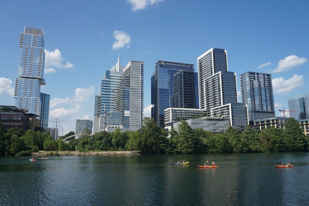 Kayakers paddling Lady Bird Lake below the downtown Austin skyline