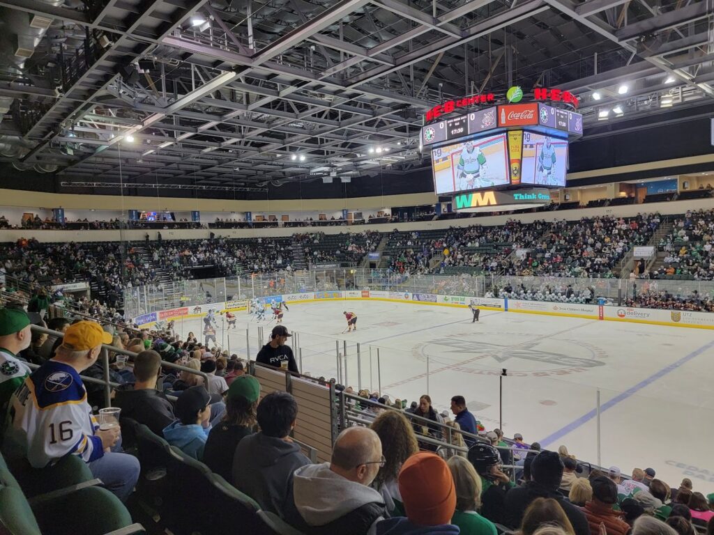 A Texas Stars hockey game inside the H-E-B Center at Cedar Park, with fans in the stands and the scoreboard above the ice