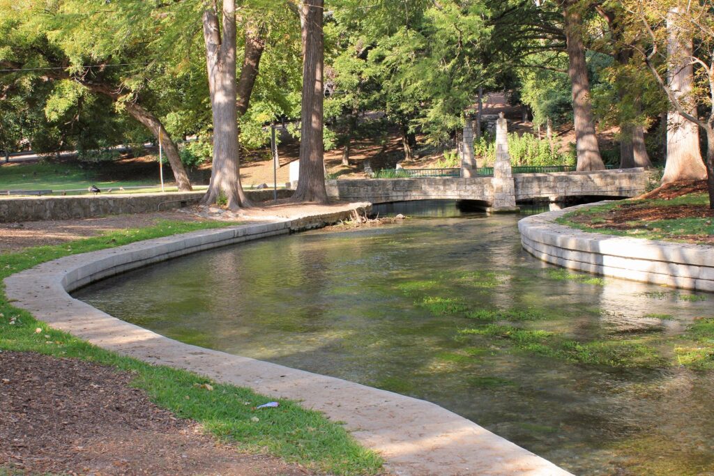 The clear, spring-fed Comal River curving through Landa Park in New Braunfels under tall cypress and pecan trees
